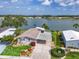Charming waterfront home featuring lush landscaping and a covered carport on a sunny day at 8439 Imperial Cir, Palmetto, FL 34221