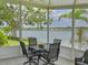 Relax on the screened porch with views of the lake; features outdoor dining set and chairs at 8439 Imperial Cir, Palmetto, FL 34221