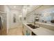 Charming kitchen boasts stainless appliances, light quartz counters, tile floors, and a seamless view into the living space at 1064 N Tamiami Trl # 1402, Sarasota, FL 34236