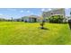 Lush backyard with green lawn and young tree featuring plenty of space for outdoor activities and relaxation at 11430 Gallatin Trl, Parrish, FL 34219