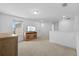 A carpeted bonus room with light walls and ceiling, featuring a television and a wooden cabinet at 11430 Gallatin Trl, Parrish, FL 34219