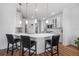 Kitchen boasts white cabinets, quartz counters, stainless steel appliances, hardwood floors, and modern pendant lighting at 11430 Gallatin Trl, Parrish, FL 34219