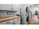 Laundry room with stacked washer and dryer, cabinets, butcher block counters and backyard access at 11430 Gallatin Trl, Parrish, FL 34219