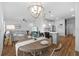 This living room features wood floors, pendant lights, a sofa, and open kitchen at 11430 Gallatin Trl, Parrish, FL 34219