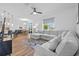 Spacious open-concept living room with ample seating, hardwood floors, ceiling fan, and natural light at 11430 Gallatin Trl, Parrish, FL 34219