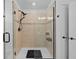 Modern glass enclosed shower with tiled walls, shelving, and sleek fixtures offering a luxurious spa-like experience at 11430 Gallatin Trl, Parrish, FL 34219