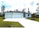 Charming single-story home featuring a two-car garage, well-manicured lawn, and a paved driveway at 12089 Mayfair Ave, Port Charlotte, FL 33981