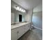 The bathroom has double sinks, white cabinets, granite countertops, and tile floors at 12127 Storke Ave, Port Charlotte, FL 33981
