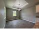 Dining room features a modern chandelier, neutral paint, tile floors, and natural light from windows at 12127 Storke Ave, Port Charlotte, FL 33981