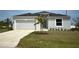 Charming single-Gathering home features a two-car garage, well-maintained lawn, and fresh landscaping at 12127 Storke Ave, Port Charlotte, FL 33981