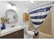 Well-lit bathroom with a nautical-themed shower curtain, vanity, and woven storage enhancing the space at 1507 45Th Avenue E Dr, Ellenton, FL 34222