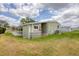 Side view of a home with awnings, well-kept lawn, and a ladder, showcasing its features and upkeep at 1507 45Th Avenue E Dr, Ellenton, FL 34222