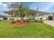 Charming home featuring a landscaped front yard with a beautiful palm tree at 1507 45Th Avenue E Dr, Ellenton, FL 34222