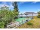 Fenced backyard features an artificial lawn, flowerbeds, a swing set, and a view of the white-fenced neighboring property at 1657 Bonita Bluff Ct, Ruskin, FL 33570
