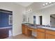 Bathroom featuring a vanity with double sinks and a large mirror, and access to a walk-in closet at 1657 Bonita Bluff Ct, Ruskin, FL 33570