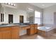 Bathroom with dual sinks, a soaker tub, and a large mirror at 1657 Bonita Bluff Ct, Ruskin, FL 33570