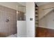 Bathroom featuring a tiled shower, a shelf unit, and neutral wall paint at 1657 Bonita Bluff Ct, Ruskin, FL 33570
