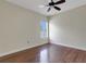 An empty bedroom showcasing hardwood floors, a window, ceiling fan, and ample natural light at 1657 Bonita Bluff Ct, Ruskin, FL 33570