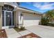 Charming home exterior featuring a two-car garage, well-manicured landscaping, and a decorative front door at 1657 Bonita Bluff Ct, Ruskin, FL 33570