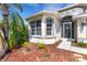 Close-up of the front exterior featuring arched windows, a decorative door, and low-maintenance landscaping at 1657 Bonita Bluff Ct, Ruskin, FL 33570