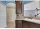 Charming kitchen area featuring dark wood cabinets, tile backsplash, and view of a secondary living space at 1657 Bonita Bluff Ct, Ruskin, FL 33570