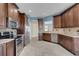Spacious kitchen features dark wood cabinetry, stainless steel appliances, and stylish tile flooring at 1657 Bonita Bluff Ct, Ruskin, FL 33570