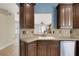 Stylish kitchen showcasing dark wood cabinets, tile backsplash, and a glimpse of a living room area at 1657 Bonita Bluff Ct, Ruskin, FL 33570