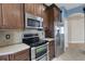 Kitchen boasts stainless appliances, dark wood cabinets, and tile backsplash for modern appeal at 1657 Bonita Bluff Ct, Ruskin, FL 33570