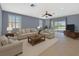 Cozy living room with comfortable seating, a ceiling fan, and natural light from the windows at 1657 Bonita Bluff Ct, Ruskin, FL 33570