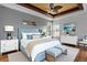 This main bedroom offers a tray ceiling, a ceiling fan, and a coastal view at 1657 Bonita Bluff Ct, Ruskin, FL 33570