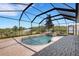 A beautiful screened-in pool includes a built-in spa with a waterfall feature and brick patio at 1657 Bonita Bluff Ct, Ruskin, FL 33570