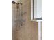 Close-up of a shower with tiled walls, shelves, and an adjustable shower head at 1657 Bonita Bluff Ct, Ruskin, FL 33570