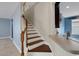 Inviting staircase with wood treads, white risers, and views into the kitchen area with light blue accent wall at 1657 Bonita Bluff Ct, Ruskin, FL 33570