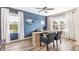 Well-lit home office with wood floors, a desk, and an accent wall at 17429 Haysack Ter, Lakewood Ranch, FL 34211