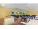 Clubhouse interior with ceiling fans, a kitchen area, tables, and chairs for social gatherings at 18114 Metado Dr, Bradenton, FL 34211