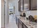Walk-in pantry area featuring granite countertop space and dark wood cabinets at 18114 Metado Dr, Bradenton, FL 34211
