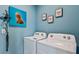 Functional laundry room with washer, dryer, and decor at 18219 Wheathouse Pl, Lakewood Ranch, FL 34211