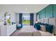 Bright and airy main bedroom with a large window, teal decor, and stylish furniture at 18219 Wheathouse Pl, Lakewood Ranch, FL 34211