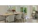 A stylish dining room featuring a wood table with seating for eight and views of the outdoor greenery at 18220 Canopy Pl, Lakewood Ranch, FL 34211