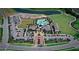 Aerial view of the community featuring a pool, clubhouse, parking, and green spaces near a lake at 18220 Wheathouse Pl, Lakewood Ranch, FL 34211