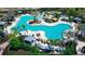 Resort-style pool with lounge chairs and umbrellas surrounded by lush landscaping and palm trees at 18220 Wheathouse Pl, Lakewood Ranch, FL 34211