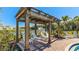 Pool-side pergola with lounge chairs overlooking a serene lake and fountain at 18223 Canopy Pl, Lakewood Ranch, FL 34211