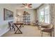 Comfortable office featuring neutral paint, ceiling fan, and rustic wooden desk with stylish black and white chair at 18223 Wheathouse Pl, Lakewood Ranch, FL 34211