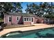 A serene pool area with a home, deck, and lush greenery for a relaxing backyard at 1830 Virginia Dr, Bradenton, FL 34205