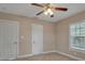 Neutral bedroom featuring a ceiling fan, tiled flooring, and white trim, complemented by natural light at 1830 Virginia Dr, Bradenton, FL 34205