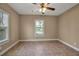 Cozy bedroom with neutral colors, large window, tiled floor, and a ceiling fan at 1830 Virginia Dr, Bradenton, FL 34205