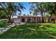 Charming single-story home with an attached garage, a well-maintained lawn and mature trees at 1830 Virginia Dr, Bradenton, FL 34205