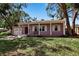 Charming single-story home with an attached garage, a well-maintained lawn and mature trees at 1830 Virginia Dr, Bradenton, FL 34205