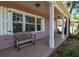 Inviting front porch featuring a wooden bench and white columns offering a relaxing outdoor space at 1830 Virginia Dr, Bradenton, FL 34205
