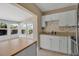 Eat-in kitchen featuring white cabinets, stainless steel appliances, and bright natural light at 1830 Virginia Dr, Bradenton, FL 34205